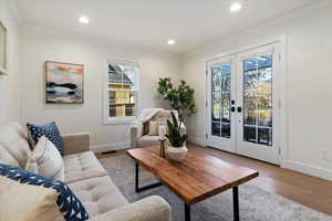 Living room featuring french doors, wood finished floors, recessed lighting, and ornamental molding