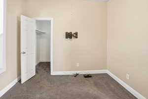 Unfurnished bedroom featuring a spacious closet and carpet flooring