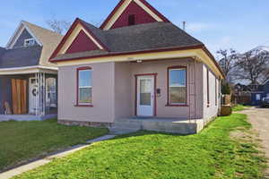 View of the front of the home featuring brick, a covered porch, and yard.