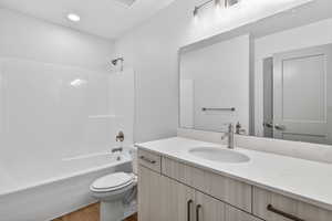 Bathroom featuring vanity, tub / shower combination, and light wood-style flooring
