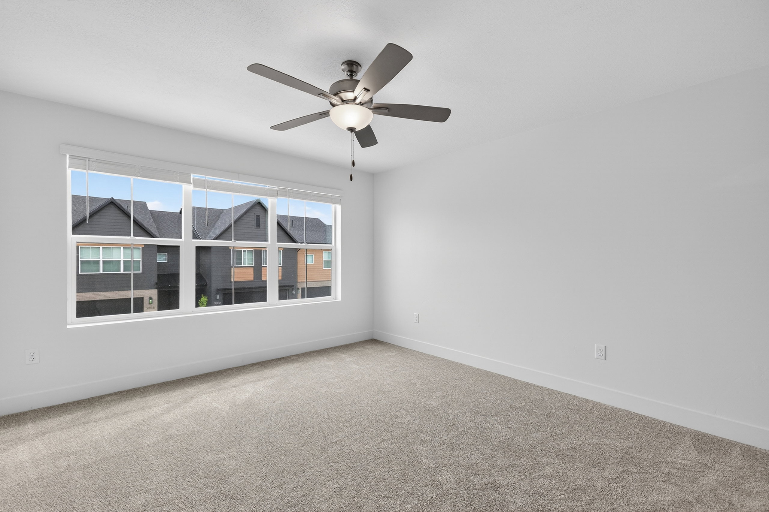 Carpeted empty room with baseboards and ceiling fan
