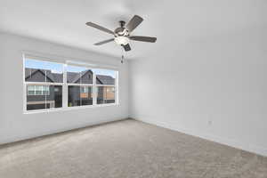 Carpeted empty room with baseboards and ceiling fan
