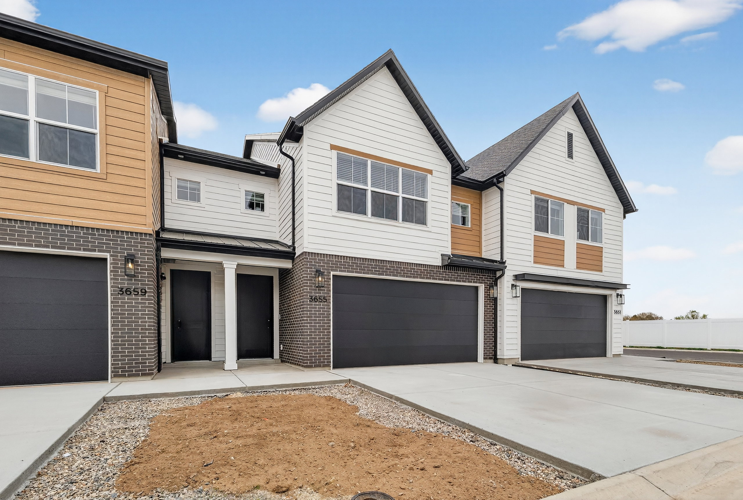 Modern home with brick siding, an attached garage, and concrete driveway