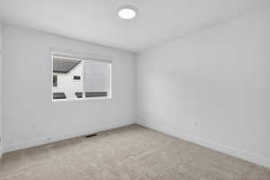 Spare room with baseboards and light colored carpet