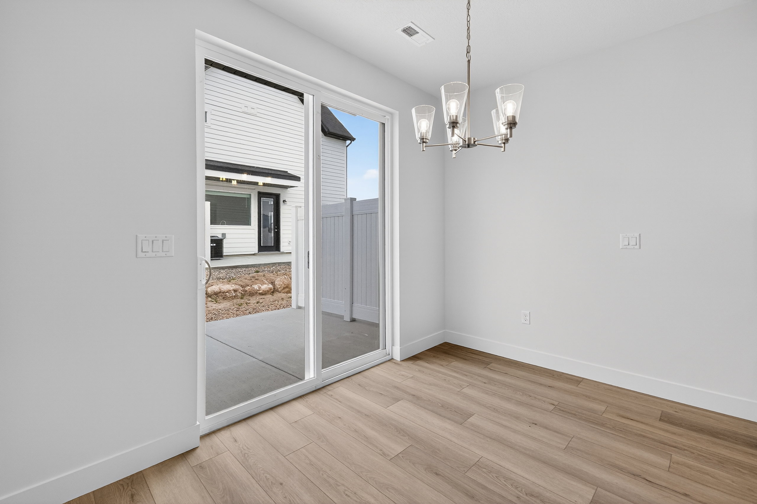 Unfurnished dining area featuring suspended lighting and light wood-style floors