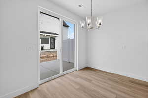 Unfurnished dining area featuring suspended lighting and light wood-style floors
