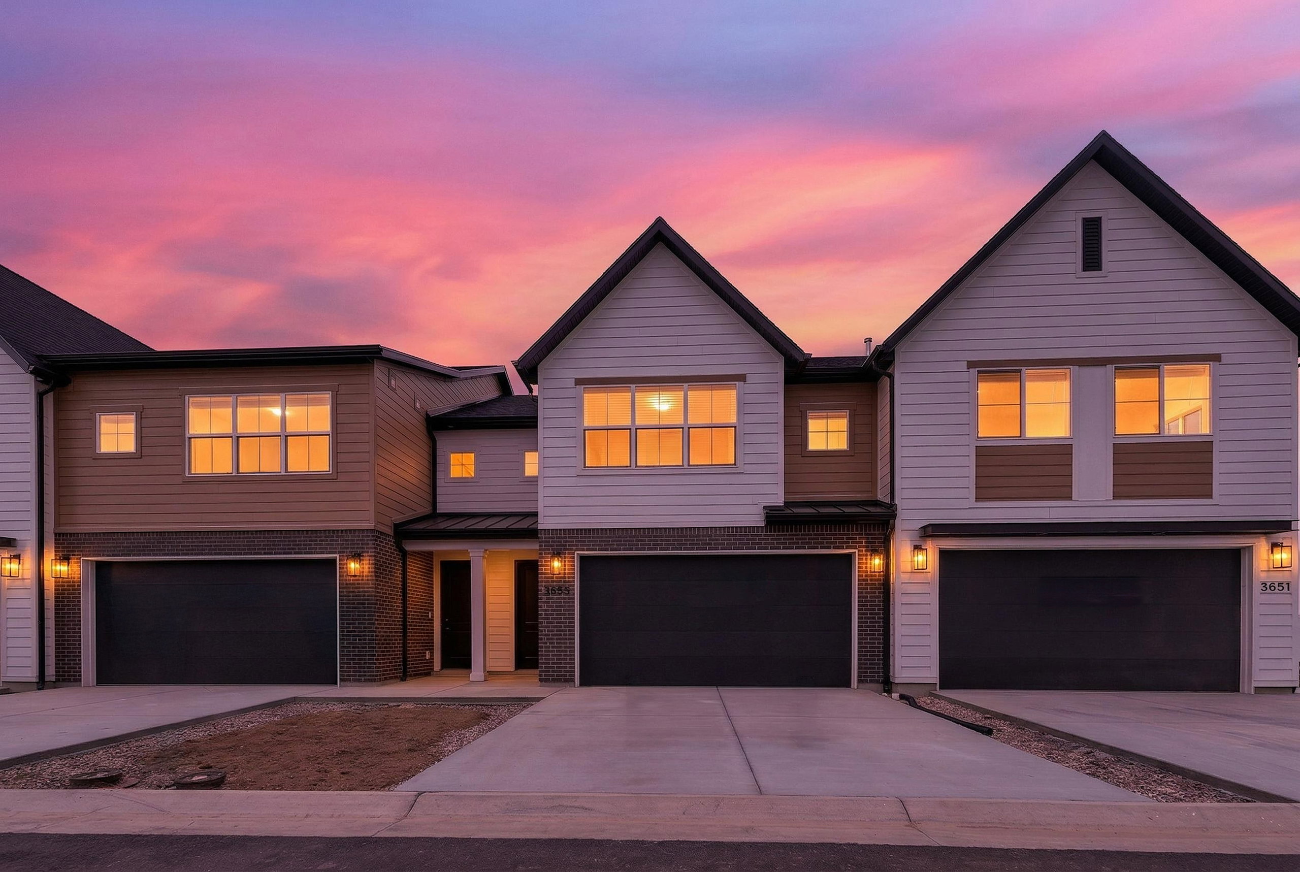 View of front of home with concrete driveway, an attached garage, and brick siding