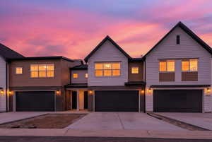 View of front of home with concrete driveway, an attached garage, and brick siding