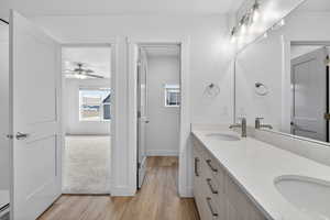 Bathroom with double vanity and light wood-style floors