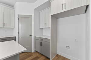 Two tone kitchen with two tone color scheme, dark wood finished floors, light stone counters, backsplash, and modern cabinets