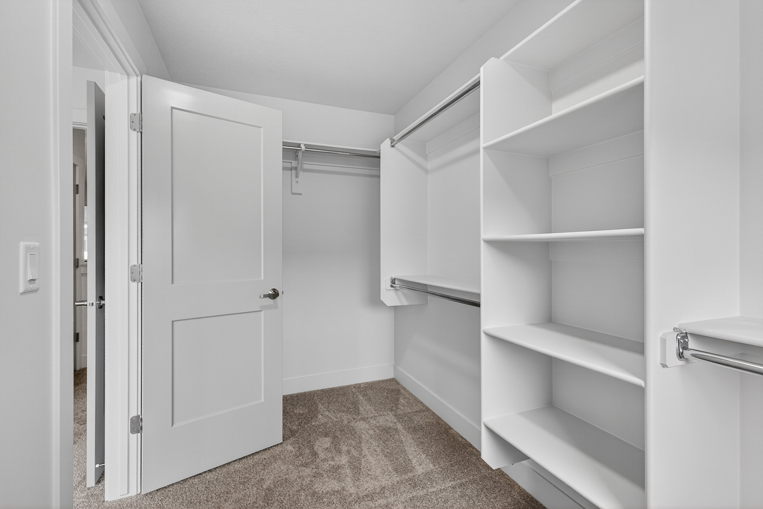 Walk in closet with dark colored carpet