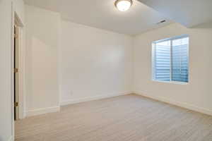 Empty room featuring light colored carpet and a textured ceiling