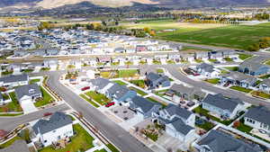 Aerial view of property and surrounding area featuring a mountainous background and nearby suburban area