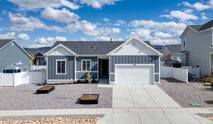 Ranch-style home featuring board and batten siding, driveway, a garage, and a residential view