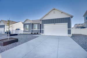 Ranch-style house with board and batten siding, concrete driveway, and an attached garage