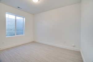 Empty room featuring light carpet and baseboards