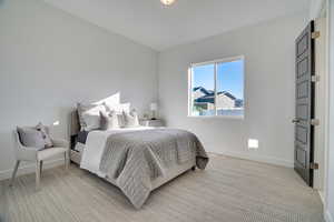 Bedroom with light carpet and baseboards