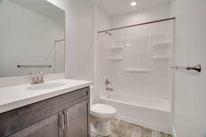 Full bath with vanity, light wood-style flooring, shower / bathtub combination, and recessed lighting