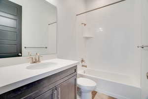 Bathroom featuring vanity,  shower combination, and light wood finished floors