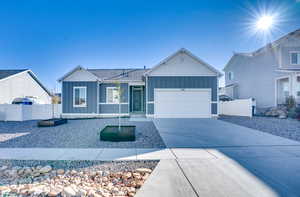 Ranch-style home featuring board and batten siding, driveway, and an attached garage