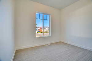 Spare room featuring light colored carpet and baseboards