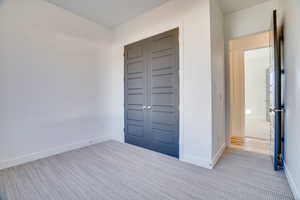 Foyer with light colored carpet and baseboards