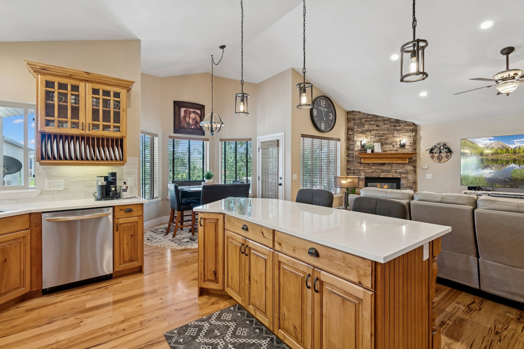 Kitchen featuring dishwasher, glass fronted cabinets, a fireplace, a kitchen island, and light wood finished floors