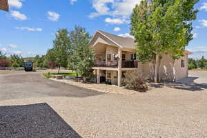 View of front of house with a balcony, a patio, and stucco siding