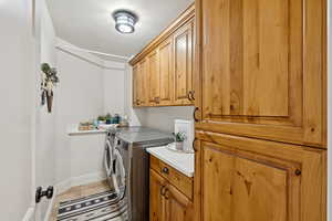 Laundry area featuring washer and clothes dryer and cabinet space
