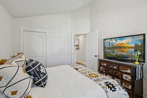 Bedroom featuring lofted ceiling and a closet