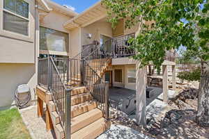 View of exterior entry featuring stucco siding and a patio area