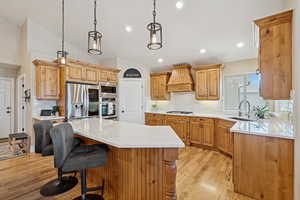 Kitchen with light wood-style flooring, stainless steel appliances, tasteful backsplash, a kitchen island, and lofted ceiling
