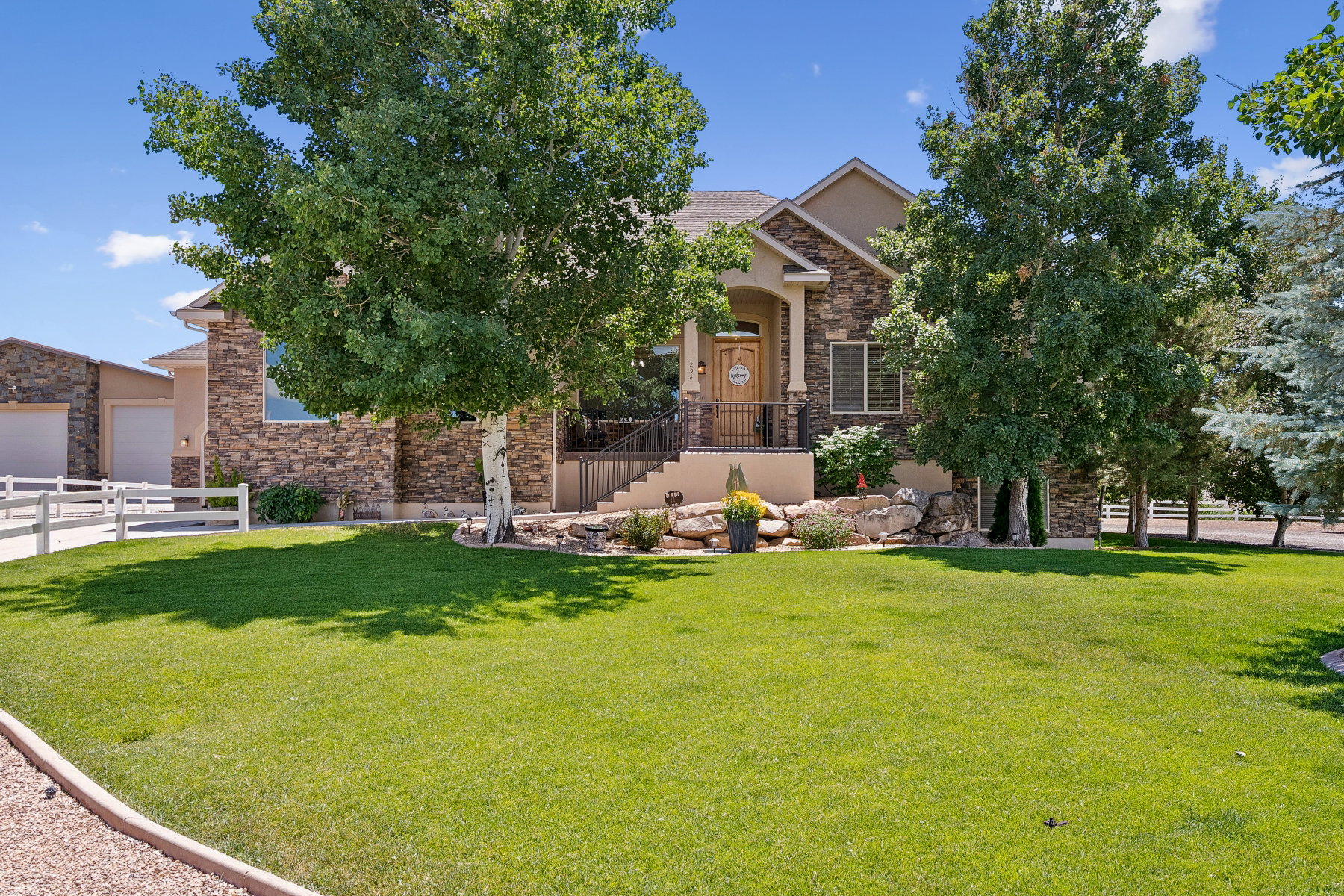 View of property hidden behind natural elements with stone siding