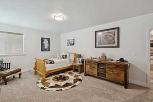 Bedroom featuring light carpet and baseboards
