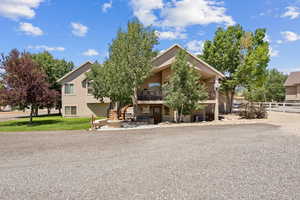 View of front facade with a balcony, stucco siding, and a patio area