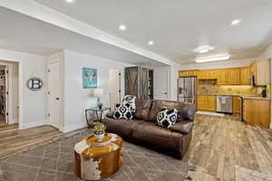 Living area featuring light wood finished floors and recessed lighting