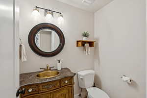 Half bathroom featuring vanity and toilet