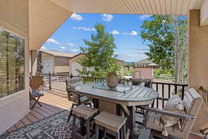 View of wooden balcony with outdoor dining area and a wooden deck
