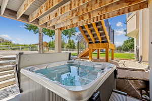 View of patio featuring a hot tub and stairway