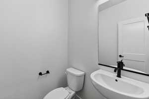 Half bathroom featuring toilet and a sink