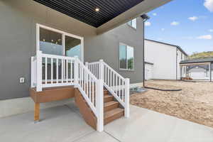 View of exterior entry featuring a patio and stucco siding