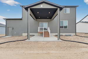 Rear view of house with a patio and stucco siding