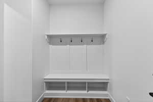Mudroom featuring dark wood-type flooring and baseboards