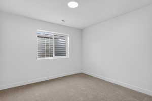 Empty room with light carpet and baseboards