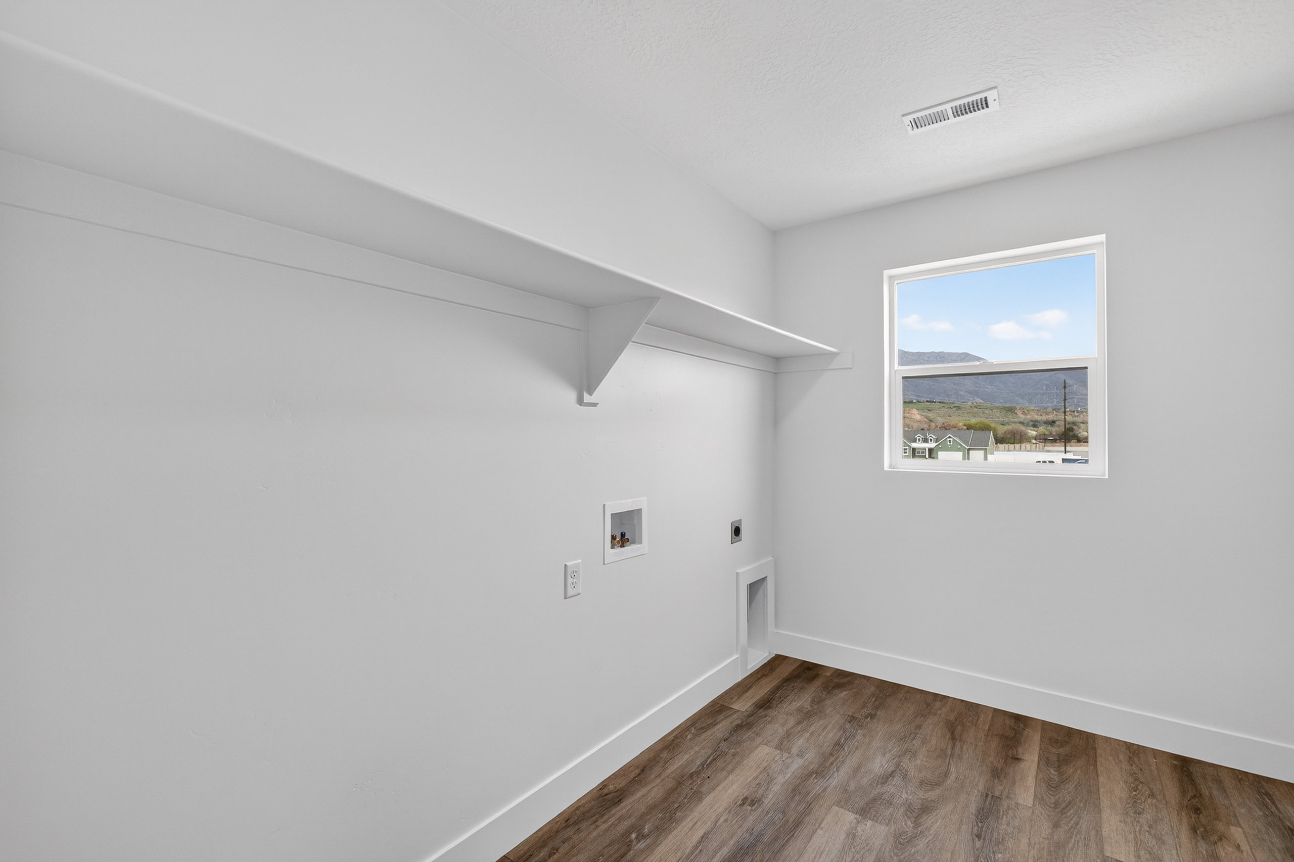 Laundry area featuring wood finished floors, hookup for an electric dryer, and washer hookup