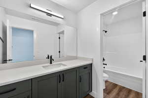 Full bath featuring vanity, dark wood finished floors, and bathtub / shower combination