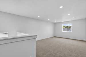 Spare room featuring light colored carpet and recessed lighting
