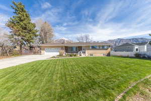 View of front of property with a garage, a mountain view, concrete driveway, and a porch