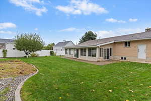 Rear view of property featuring a sunroom, garden area and fenced backyard