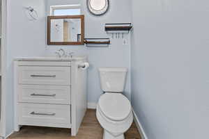 Half bathroom featuring vanity and light wood-style flooring